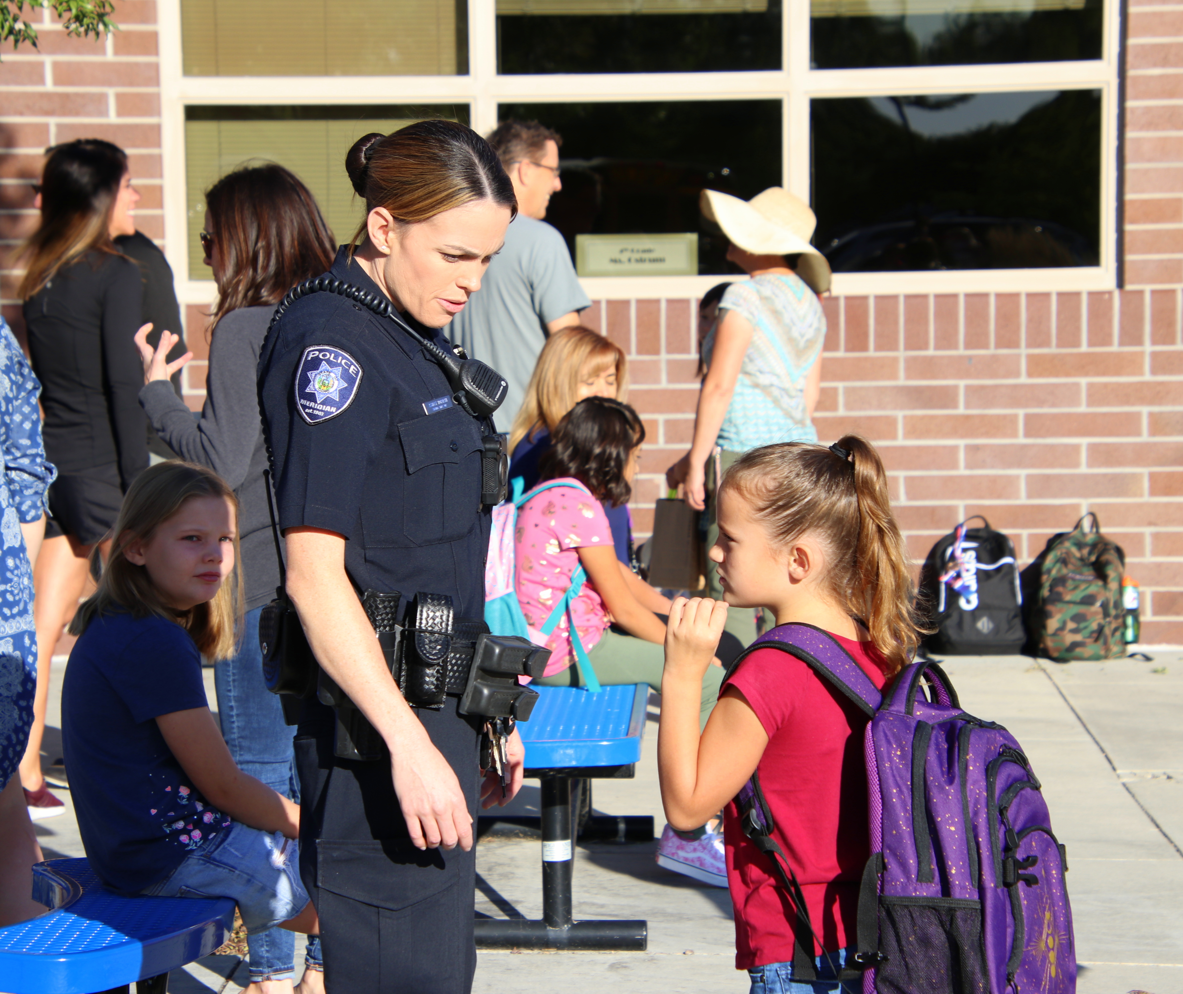 A Meridian School Resource Officer talking to an elementary school child.